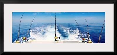 Fishing reels with cast lines off the back of a boat