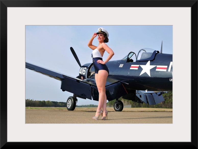 Beautiful 1940's style Navy pin-up girl posing with a vintage Corsair aircraft.