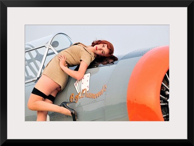 1940's style pin-up girl posing on a T-6 Texan training aircraft