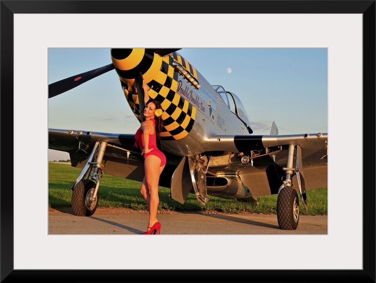 Sexy 1940's style pin-up girl posing with a P-51 Mustang fighter plane.