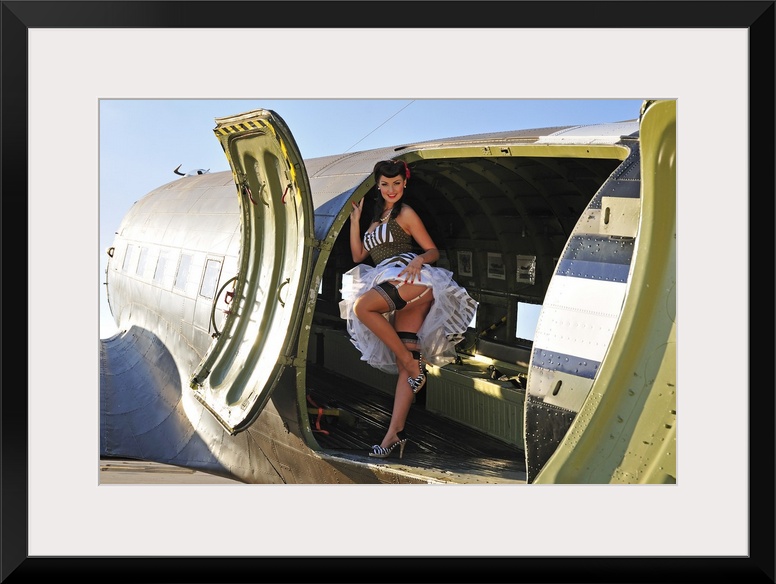 Sexy 1940's style pin-up girl with stockings, standing inside of a World War II C-47 Skytrain aircraft.