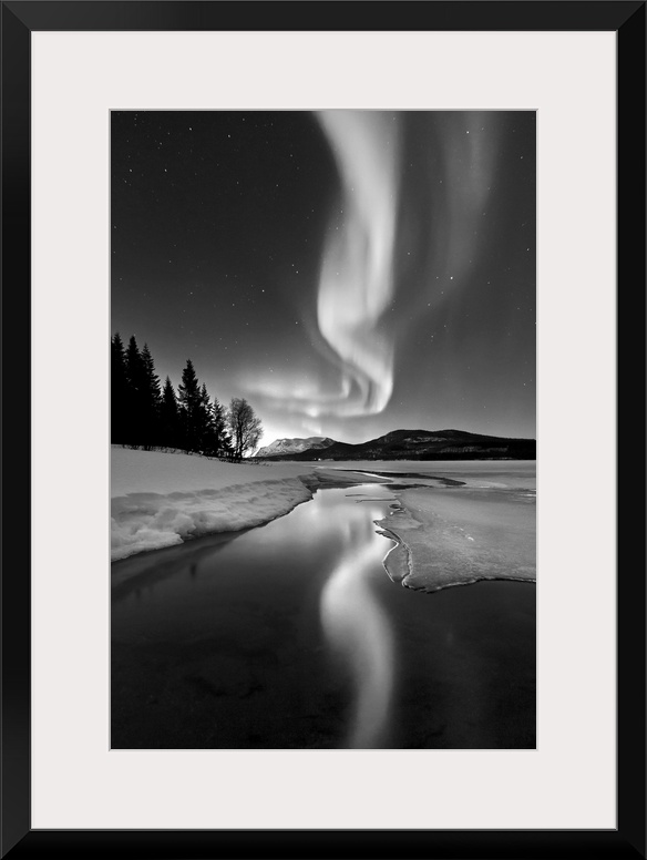 Aurora Borealis over Sandvannet Lake in Troms County, Norway. Auroras are the result of the emissions of photons in the Ea...