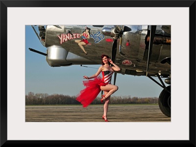 Beautiful 1940's style pin-up girl standing in front of a B-17 bomber
