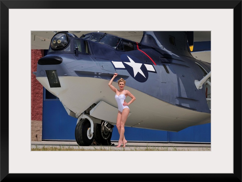 Retro pin-up girl posing with a World War II era PBY Catalina seaplane.