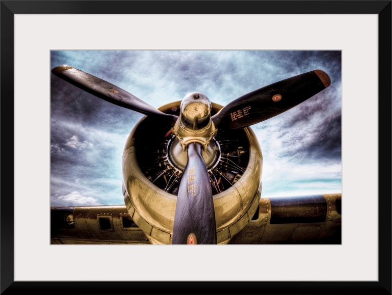 Front view photograph of vintage airplane with a dark cloudy sky in the background.