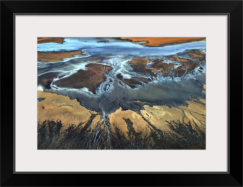 Aerial view of a desert landscape with veins of water streaming off of a main water source.