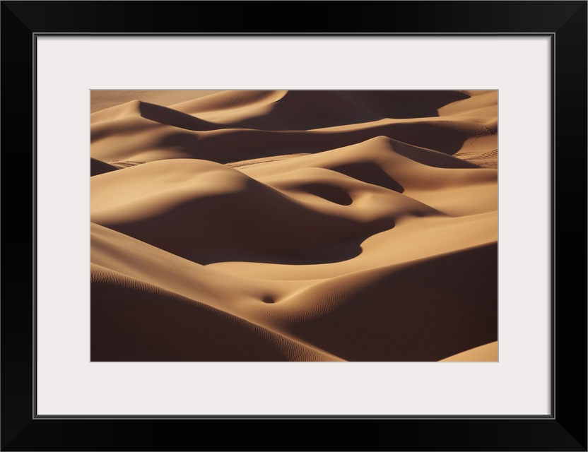 The rolling sand dunes of the Sahara desert appear smooth.