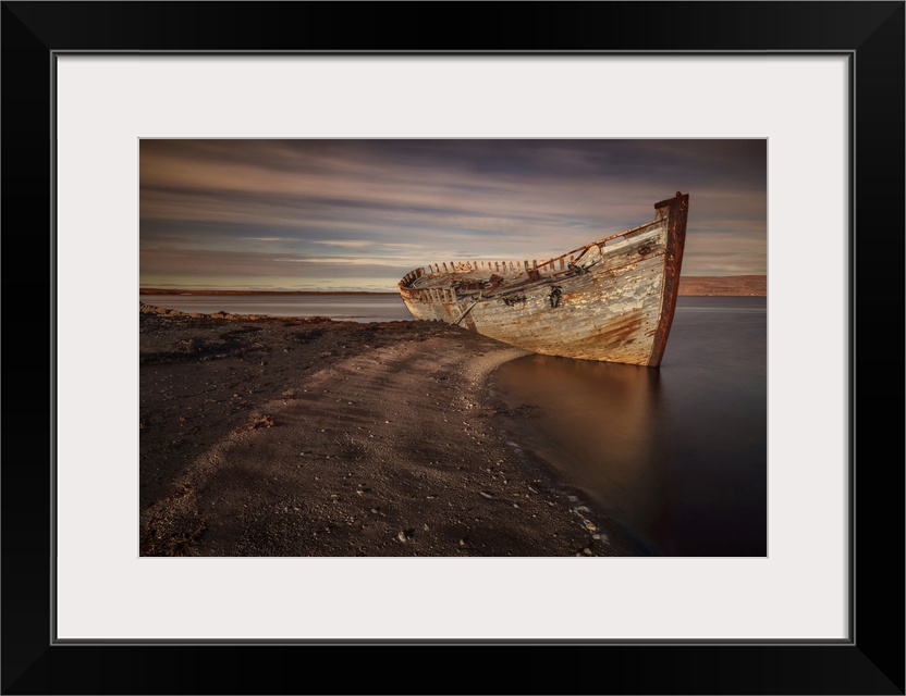 Decaying hull of an abandoned boat on the beach in Iceland.