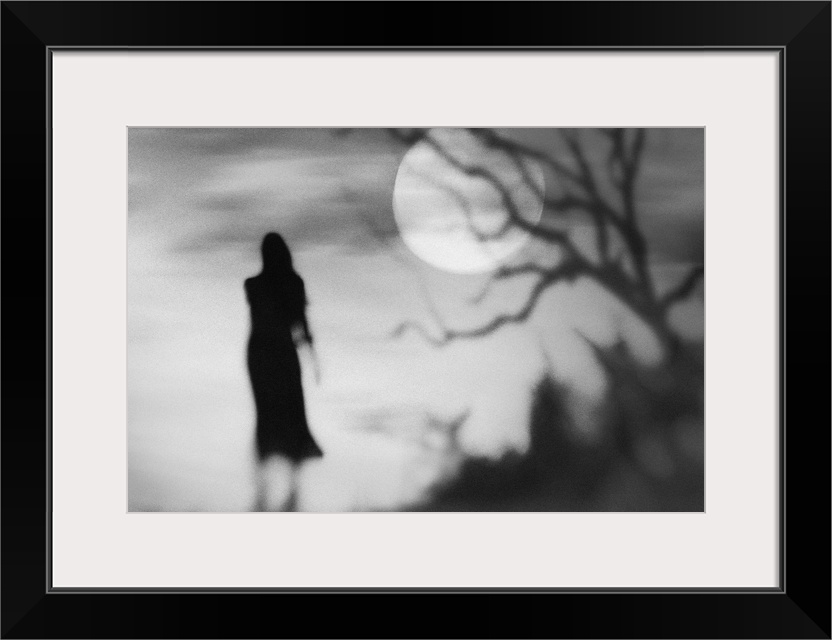 Eerie conceptual photograph of a silhouetted woman against a background with a full moon.