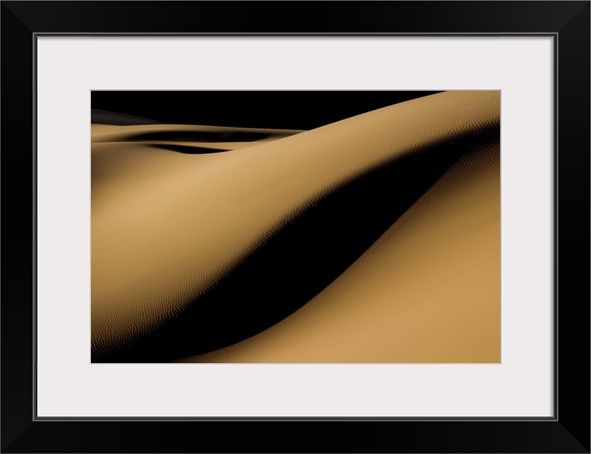 high contrast shadows create mystery as they roll over this sandy desert landscape, Iran.