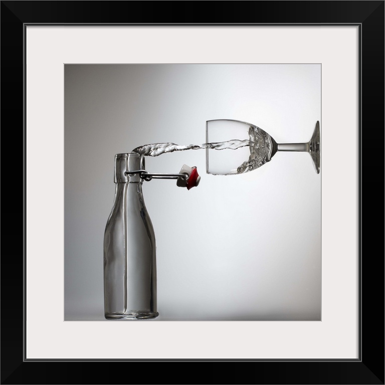 Conceptual image of water being poured from a bottle into a glass, appearing sideways.