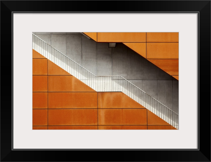 A stairway cutting through an building with an orange facade, Amsterdam.