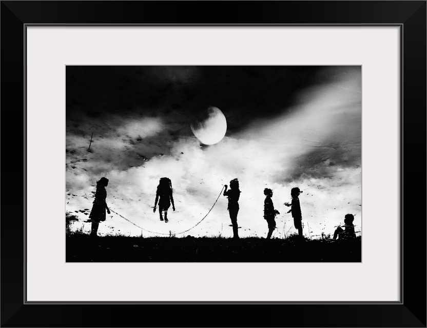 Children in silhouette jumping rope under the moonlight.