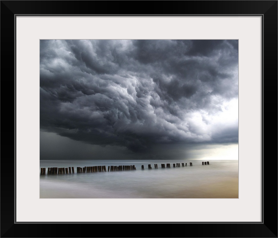 Photograph of dark, dramatic clouds rolling in over the ocean before a thunderstorm.