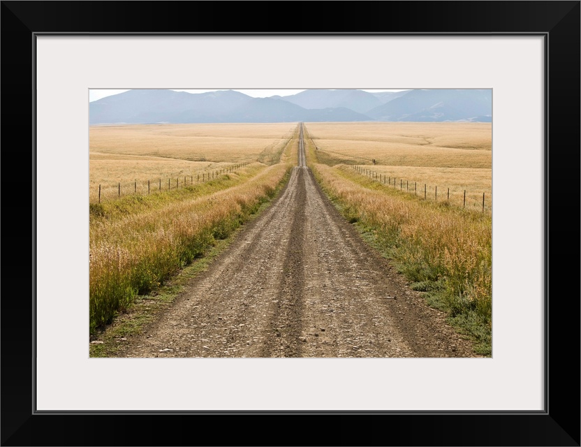 A road cuts through a prairie in the Crazy Mountains.