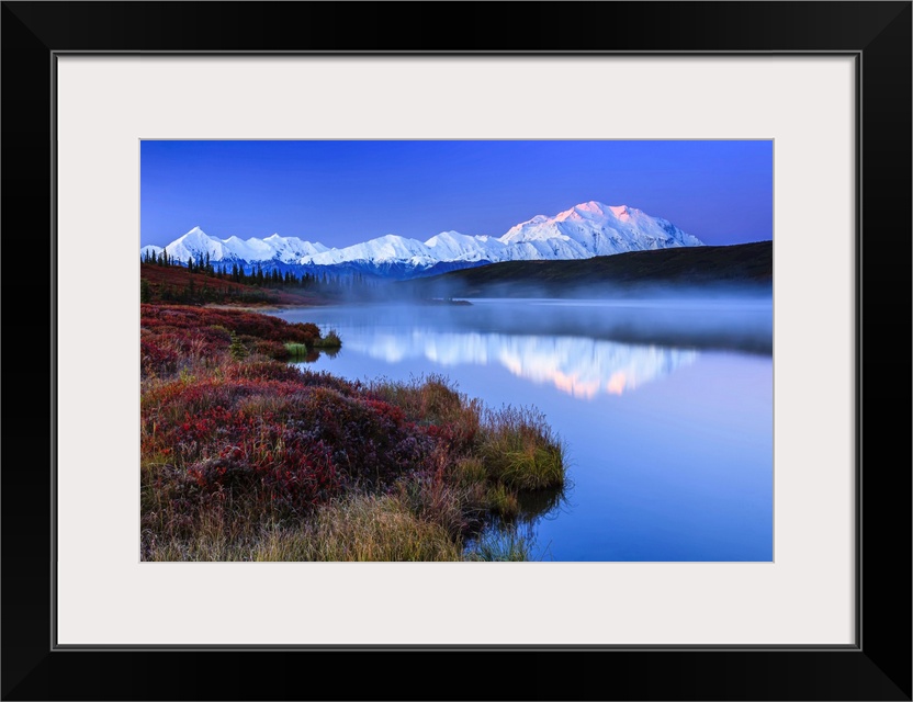 Reflection of the Alaska Range mountains in the tranquil water of Wonder Lake at sunrise in Denali National Park and Prese...