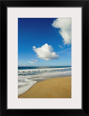 Atlantic ocean waves break on the beach on a sunny day with clouds.; Cape Hatteras, North Carolina.