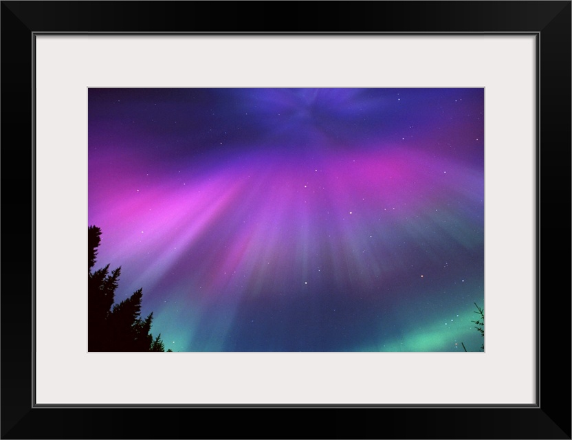 This landscape photograph captures the glow of the Northern lights and the speckles of stars beyond it.