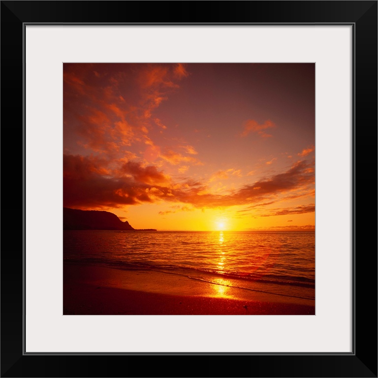 Calm Shoreline Ocean Waters With Orange Reflections From Sunset