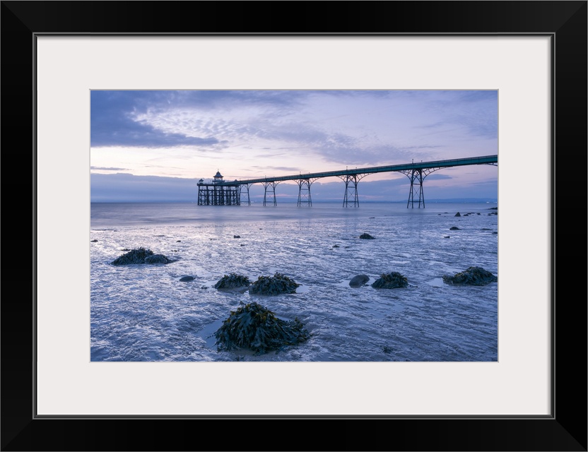 Clevedon Pier in the Severn Estuary at low tide after sunset.