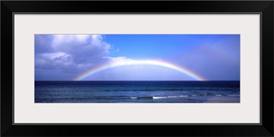 Full Rainbow Over Ocean, Large Clouds Against Blue Sky