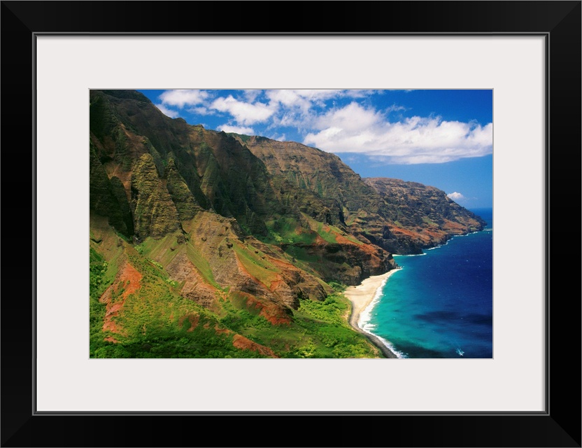 Immense cliffs that line the Hawaiian coast are photographed on a bright sunny day.