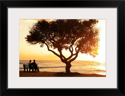 Hawaii, Oahu, Beautiful Sunset Over The Ocean With A Couple Sitting On A Bench