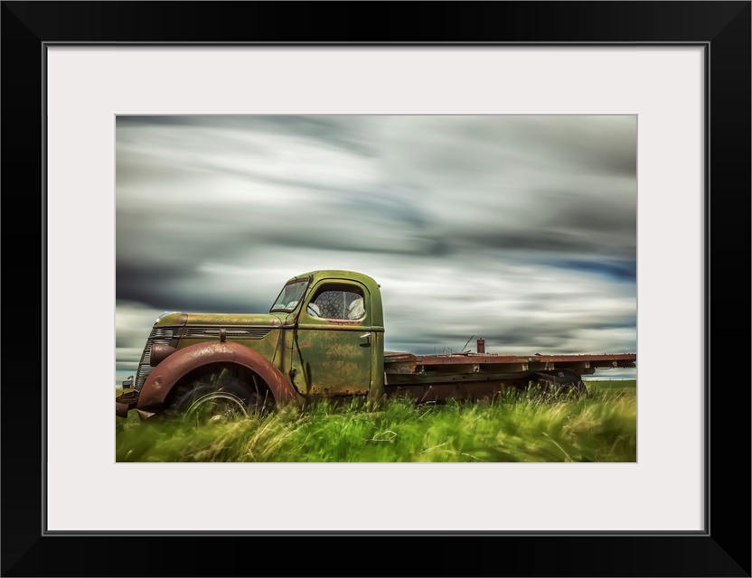 Long exposure of clouds drifting by over an abandoned truck, Saskatchewan, Canada