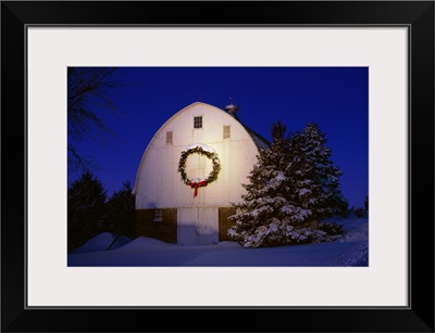 Midwestern barn in Winter snow and last light of the day with a Christmas wreath