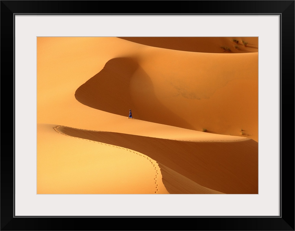 Morocco, Berber 'blue man' walking through sand dunes in Erg Chebbi area; Sahara Desert near Merzouga