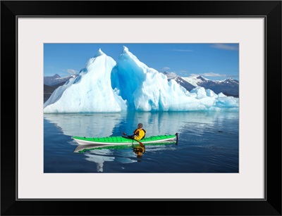 Sea Kayaker Paddles Beside An Iceberg, Alaska