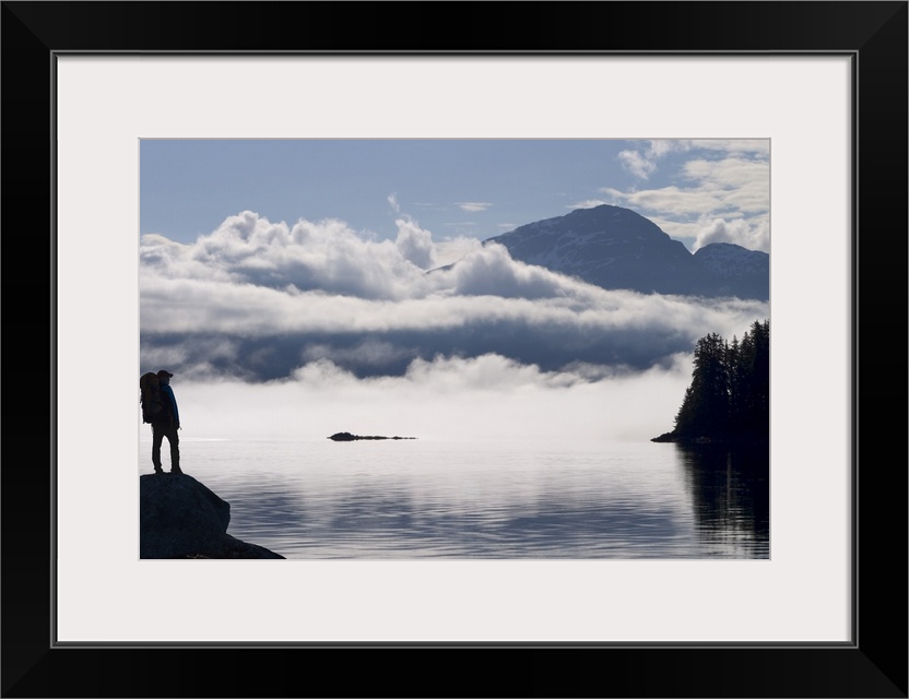 Silhouette of a backpacker along Lynn Canal near Juneau with Chilkat Mountains, Alaska