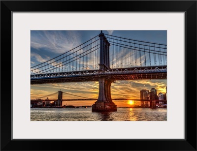 Sun setting behind Manhattan and Brooklyn Bridges; New York City