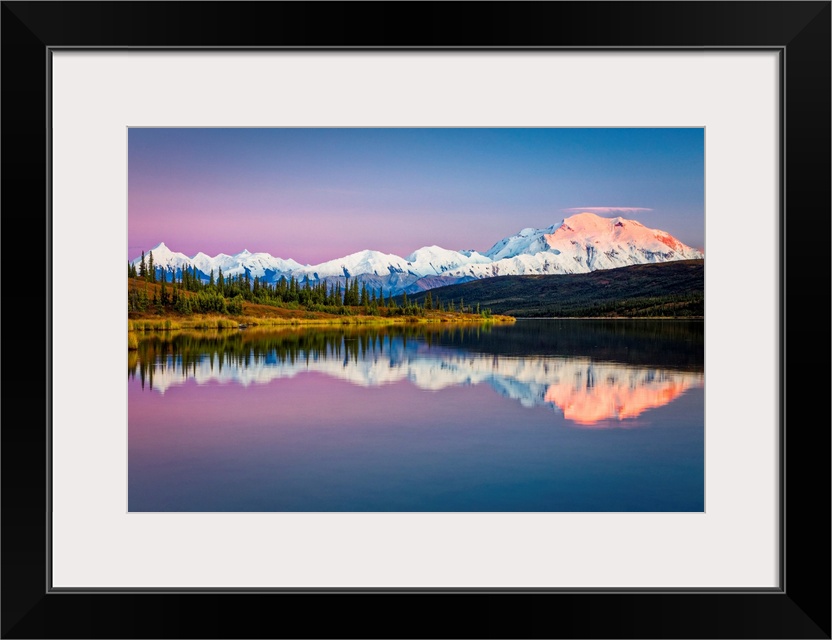 Sunset glow on Mount Denali (McKinley) reflects on Wonder Lake with pastel sky, Denali National Park and Preserve in autum...