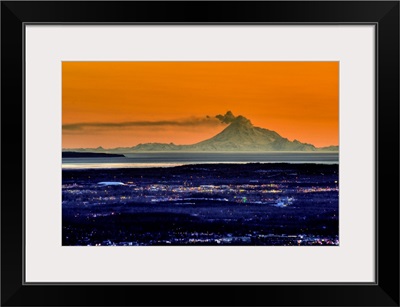 The city of Anchorage Alaska at sunset with Mount Redoubt erupting in the background