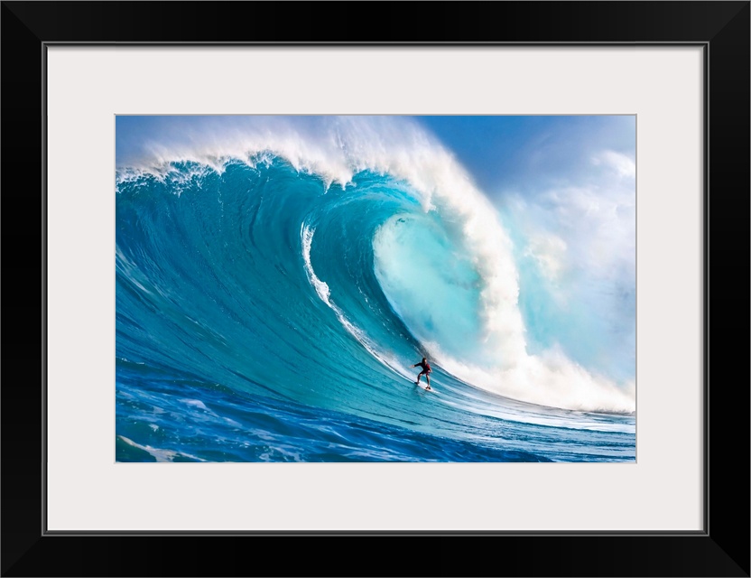 A tow-in surfer drops down the face of Hawaii's big surf at Peahi (Jaws) off North shore Maui; Maui, Hawaii, United States...