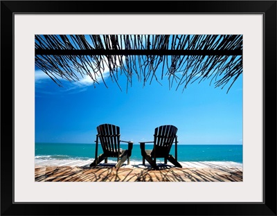 Two Chairs On Deck By Ocean Shaded By Grass Roof; Jamaica
