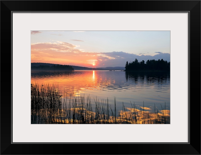 Canvas print of a peaceful lake with a sunset reflected onto it.
