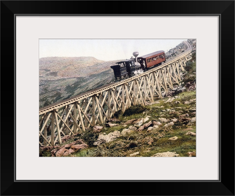 A locomotive pushes a passenger car up a wood railway to the top of a mountain in this vintage landscape photograph.