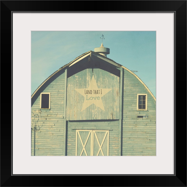 Square photograph of a blue tinted barn with a star sign that reads "Land That I Love" on the top.