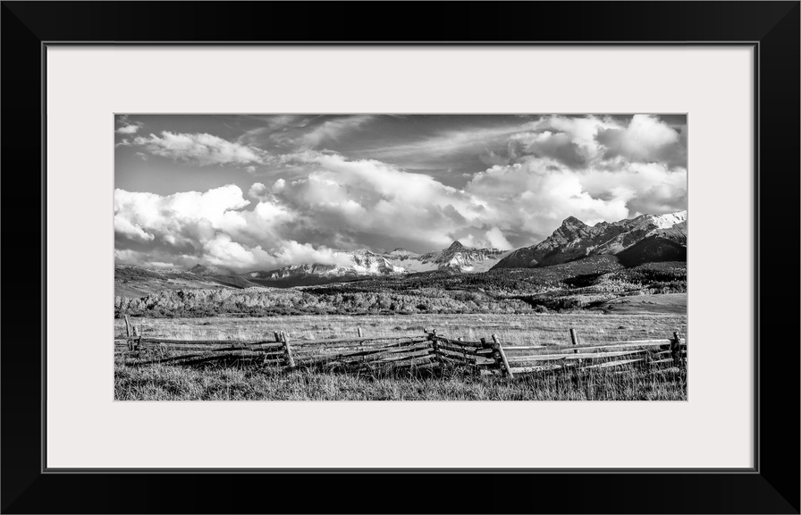 Fence on a farm, mountains in the background, black and white photograph