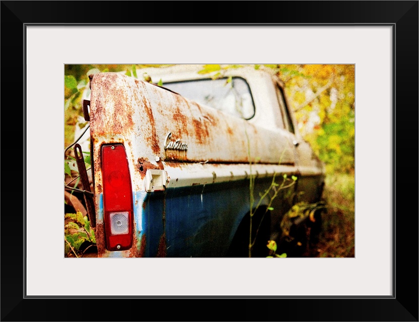 Photograph of a derelict truck in the woods.