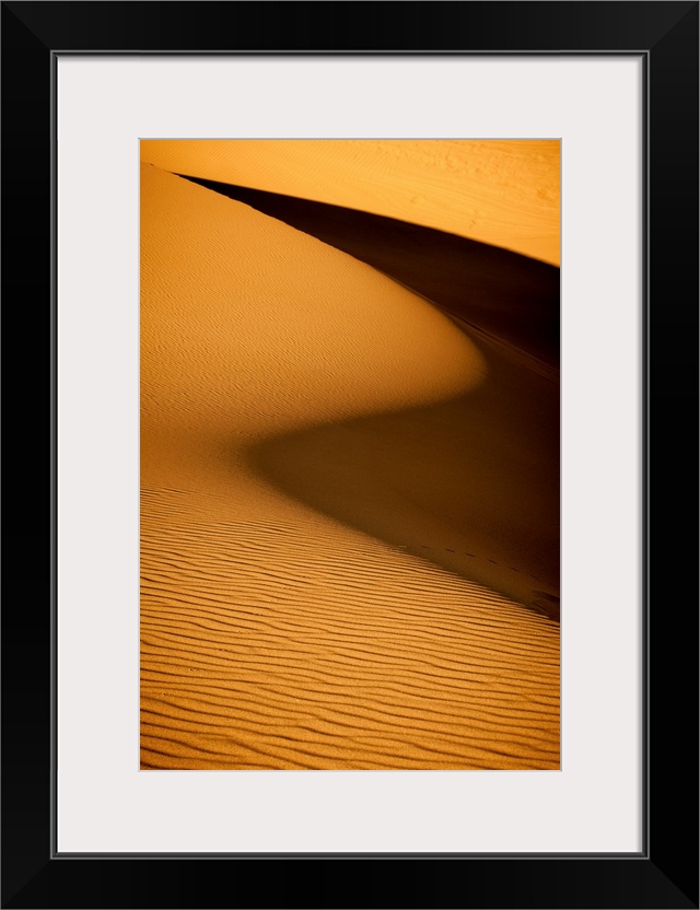 Landscape photograph of a sandy dessert terrain highlighting the textures and shadows.