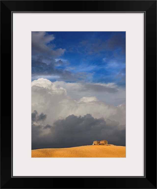 Golden wheat field, house and storm clouds