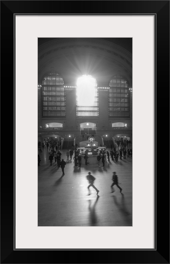 An artistic black and white photograph of silhouetted people inside Grand Central Station.