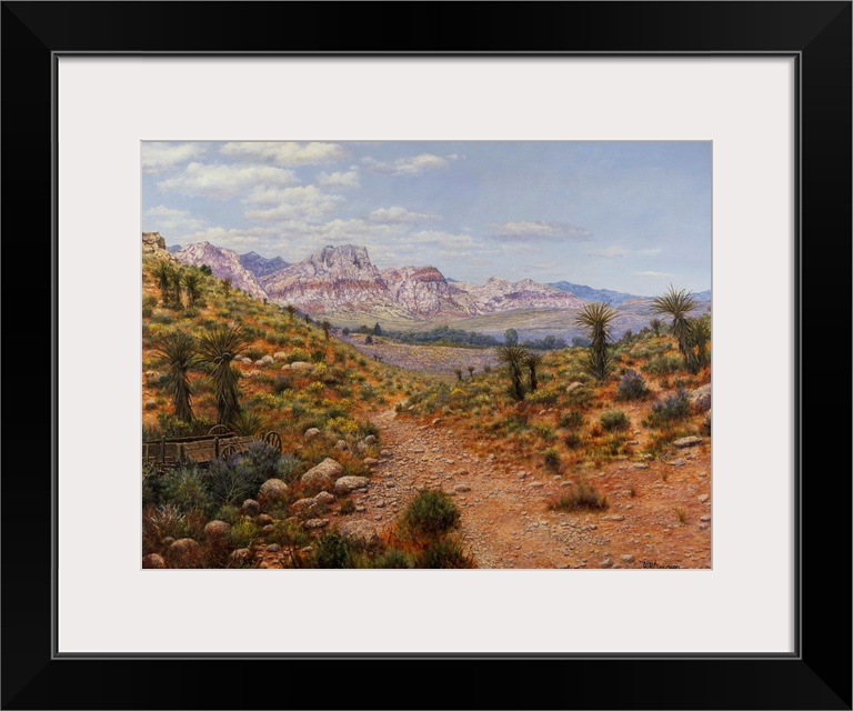 Dirt trail through arid land with canyons and water in distance.