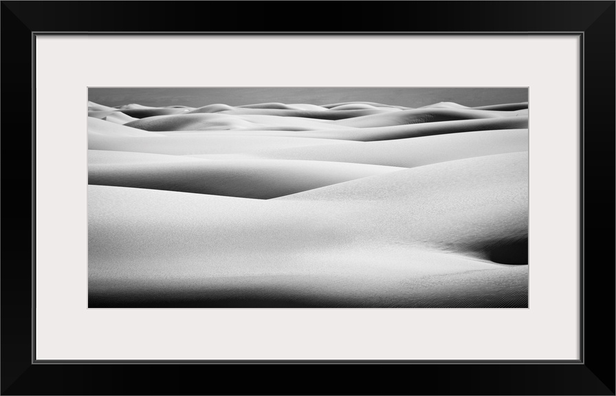 Black and white landscape photograph of contrasting hilly sand dunes.