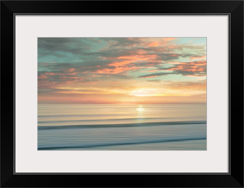 A peaceful scene of the sun slowly rising over a calm stretch of ocean. The sky glows in shades of apricot and light teal....