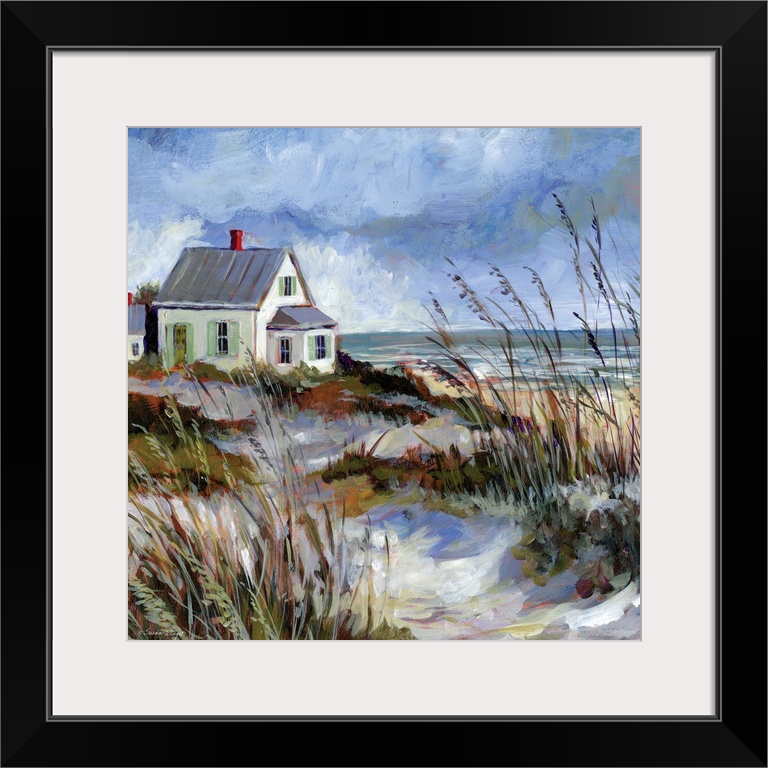 A coastal cottage sits among the dunes and water's edge.