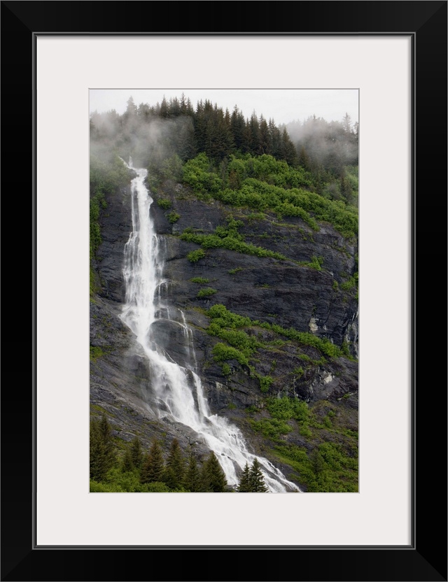 USA, Alaska, Prince William Sound, waterfall in rainforest along Harriman Fiord on rainy summer afternoon.